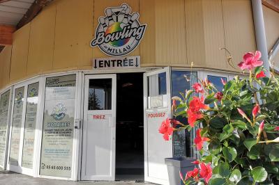Salle de réception avec une longue table dressée, des chaises rouges et noires, et une fresque murale représentant un…