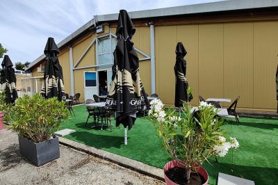 Salle de réception avec une longue table dressée, des chaises rouges et noires, et une fresque murale représentant un…
