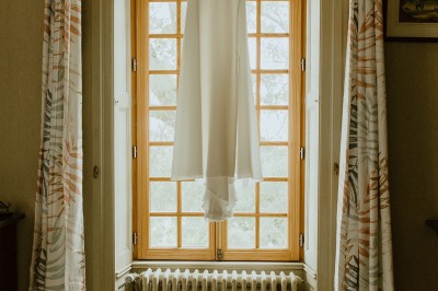 Miniature Location salle L'Orbrie (Vendée) - Le Logis des Arçonnières #74 Un couple marche dans un jardin verdoyant en direction d'une grande maison en pierre avec des volets blancs.
