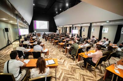 Salle élégante avec tables rondes dressées pour un repas, décorée de rideaux dorés, miroirs et mobilier classique.