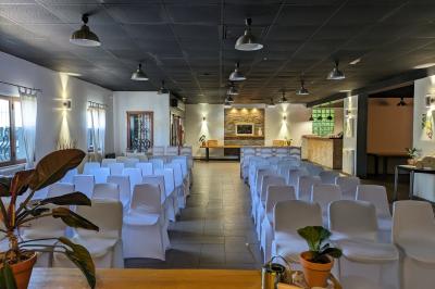 Salle de réception décorée avec des tables rondes dressées, nappes blanches et éclairage suspendu.