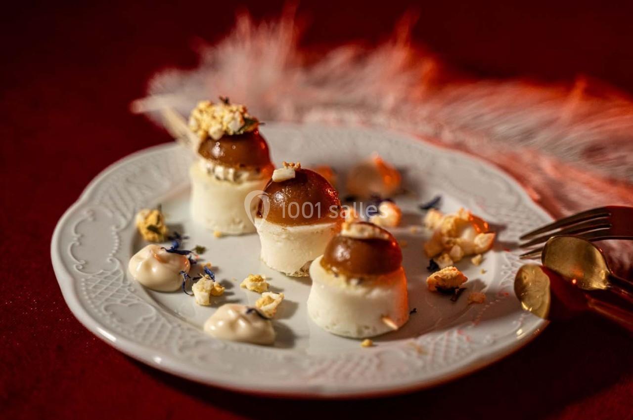 Assiette de desserts raffinés avec mousse, caramel et éclats de popcorn, présentée sur une nappe rouge.