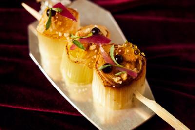 Assiette de desserts raffinés avec mousse, éclats de maïs soufflé et crème, présentée sur une nappe rouge.