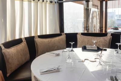 Plantes en pot sur une terrasse couverte avec des tables dressées et des chaises en osier.