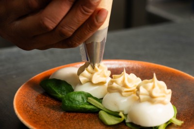 Desserts variés sur une table, incluant un tiramisu décoré d'une tranche d'orange, une mousse au chocolat et un cappuccino.