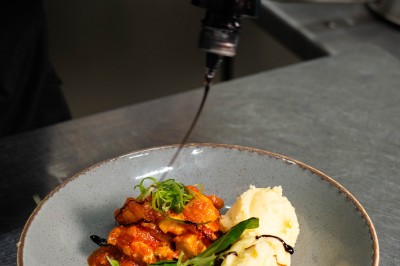Desserts variés sur une table, incluant un tiramisu décoré d'une tranche d'orange, une mousse au chocolat et un cappuccino.