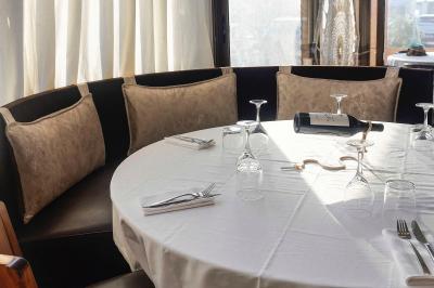 Plantes vertes en pot décorant une terrasse couverte avec des tables et des chaises disposées en arrière-plan.