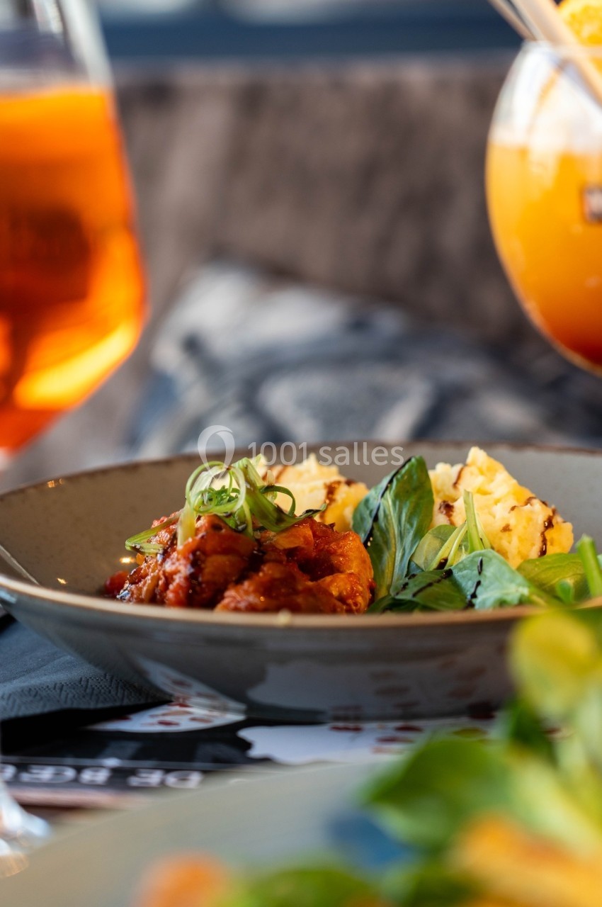 Plat de légumes mijotés avec des herbes fraîches, accompagné de purée, servi dans une assiette en céramique.
