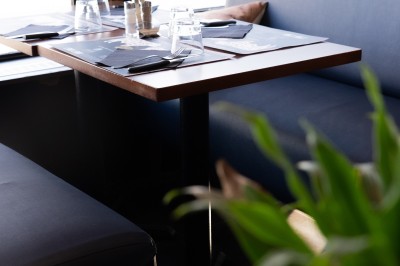 Trois cocktails variés sur une table en bois, comprenant un verre de Lillet, un cocktail au martini et un verre de Negroni.