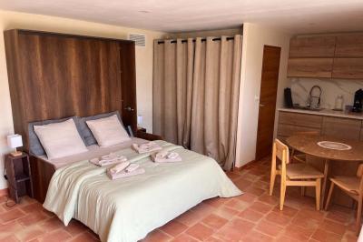 Chambre avec lit double, murs en pierre, poutres apparentes et éclairage doux, décorée de motifs muraux naturels.