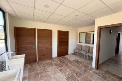 Chambre avec lit double, murs en pierre, poutres apparentes et éclairage doux, décorée de motifs muraux naturels.