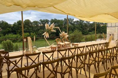 Chambre avec lit double, murs en pierre, poutres apparentes et éclairage doux, décorée de motifs muraux naturels.