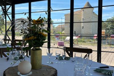 Chambre avec lit double, murs en pierre, poutres apparentes et éclairage doux, décorée de motifs muraux naturels.