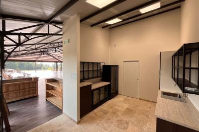 Chambre lumineuse avec un lit double, mur jaune, parquet en bois, escalier et coin détente avec fauteuils pliants.