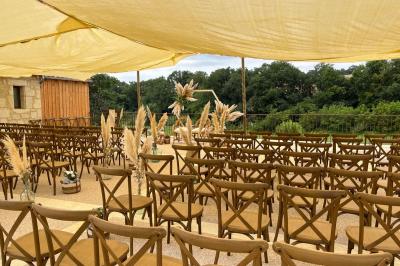 Chambre lumineuse avec un lit double, mur jaune, parquet en bois, escalier et coin détente avec fauteuils pliants.