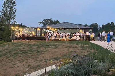 Chambre lumineuse avec un lit double, mur jaune, parquet en bois, escalier et coin détente avec fauteuils pliants.