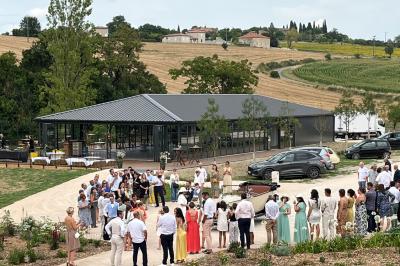 Chambre lumineuse avec un lit double, mur jaune, parquet en bois, escalier et coin détente avec fauteuils pliants.