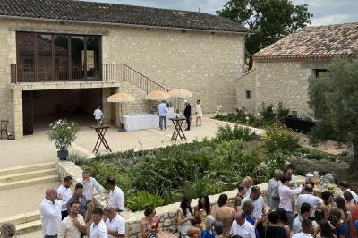 Chambre lumineuse avec un lit double, mur jaune, parquet en bois, escalier et coin détente avec fauteuils pliants.
