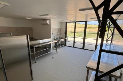 Chambre lumineuse avec un lit double, mur jaune, parquet en bois, escalier et coin détente avec fauteuils pliants.