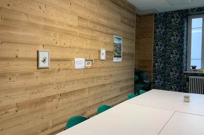 Toilettes modernes avec murs en bois clair, étagère intégrée contenant des produits ménagers dans un panier tressé.