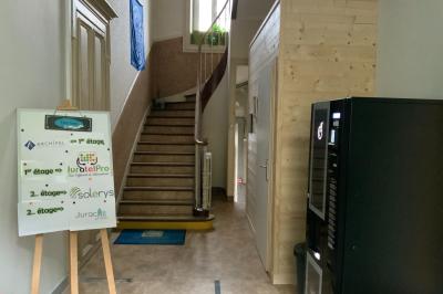 Toilettes modernes avec murs en bois clair, étagère intégrée contenant des produits ménagers dans un panier tressé.