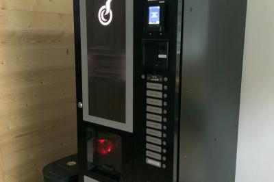 Toilettes modernes avec murs en bois clair, étagère intégrée contenant des produits ménagers dans un panier tressé.