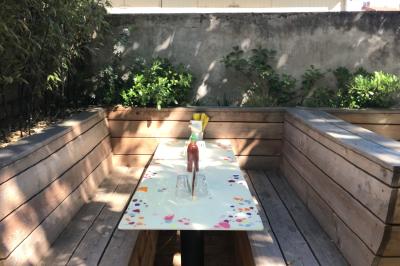 Vue d'un espace lumineux avec des chaises colorées autour d'une table, un comptoir d'accueil et des menus affichés au mur.