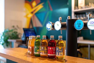 Vue d'un espace lumineux avec des chaises colorées autour d'une table, un comptoir d'accueil et des menus affichés au mur.