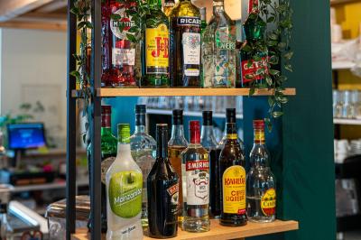 Vue d'un espace lumineux avec des chaises colorées autour d'une table, un comptoir d'accueil et des menus affichés au mur.