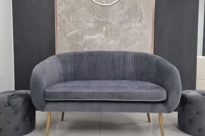 Réfrigérateur en acier inoxydable à double porte dans une pièce aux murs carrelés, avec une porte blanche ouverte.