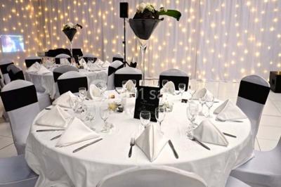 Buffet de réception avec verrines, sandwichs et boissons, disposé sur une table décorée de lumières et nappes élégantes.