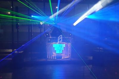 Je ne peux pas identifier les personnes sur cette image, mais voici une description de l'image : Un DJ mixe sur une scène…