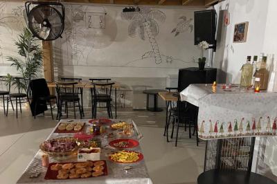 Salle décorée pour une fête avec une longue table dressée, bougies, confettis et ballons dorés.