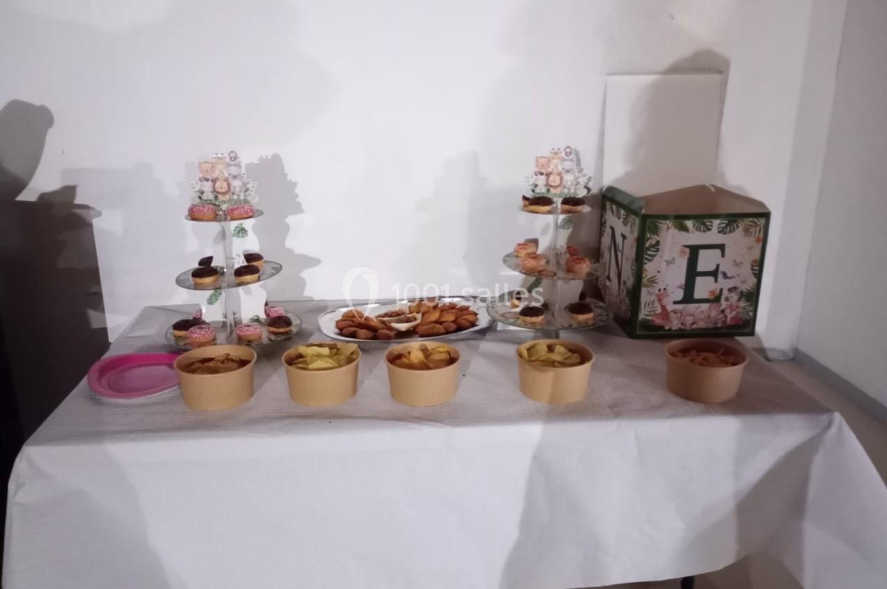 Table dressée avec des desserts variés, des gâteaux sur présentoirs et des bols contenant des snacks salés.