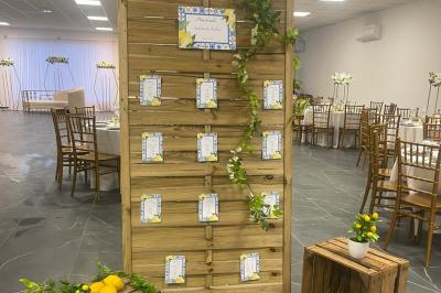 Salle de réception élégamment décorée avec des tables rondes, des chaises dorées et blanches, et des arrangements floraux.