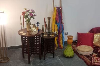 Salon décoré avec des tapis orientaux, un canapé doré, des coussins colorés et des éléments décoratifs traditionnels.