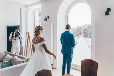 Miniature Angèle Event & Wedding #3 Salle de réception élégante avec tables dressées, chaises blanches et décorations florales sous un éclairage chaleureux.