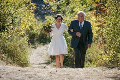 Miniature Angèle Event & Wedding #9 Salle de réception élégante avec tables dressées, chaises blanches et décorations florales sous un éclairage chaleureux.