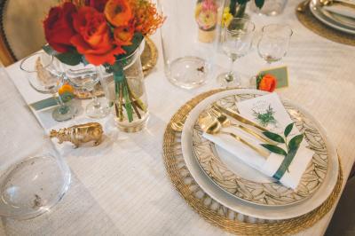 Miniature Angèle Event & Wedding #13 Salle de réception élégante avec tables dressées, chaises blanches et décorations florales sous un éclairage chaleureux.