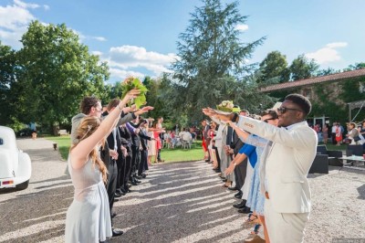 Miniature Location salle Roanne (Loire) - Château de Matel #2 Allée gravillonnée bordée de lanternes blanches menant à un jardin arboré, vue depuis un portail en fer forgé.