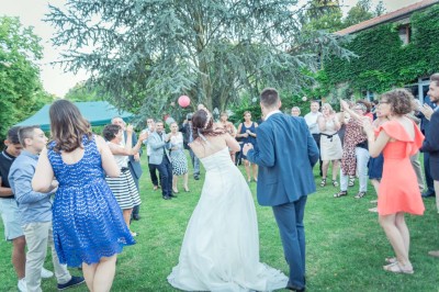 Miniature Location salle Roanne (Loire) - Château de Matel #5 Allée gravillonnée bordée de lanternes blanches menant à un jardin arboré, vue depuis un portail en fer forgé.
