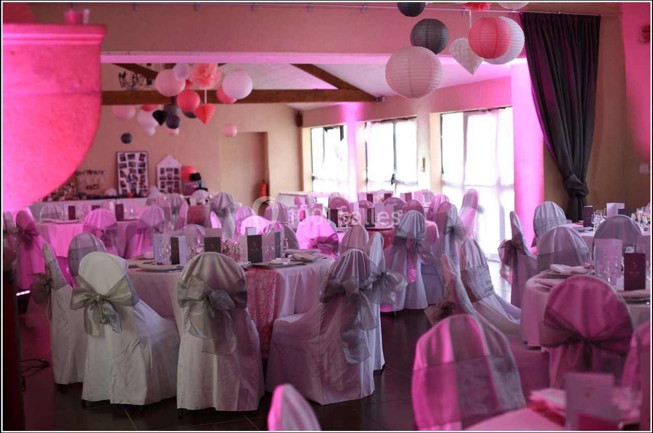 Location salle Roanne (Loire) - Château de Matel #10 Salle de réception décorée pour un événement, avec des tables dressées, des chaises couvertes et des lanternes suspendues.
