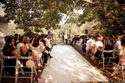 Miniature Location salle Roanne (Loire) - Château de Matel #26 Allée gravillonnée bordée de lanternes blanches menant à un jardin arboré, vue depuis un portail en fer forgé.