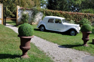 Miniature Location salle Roanne (Loire) - Château de Matel #36 Allée gravillonnée bordée de lanternes blanches menant à un jardin arboré, vue depuis un portail en fer forgé.