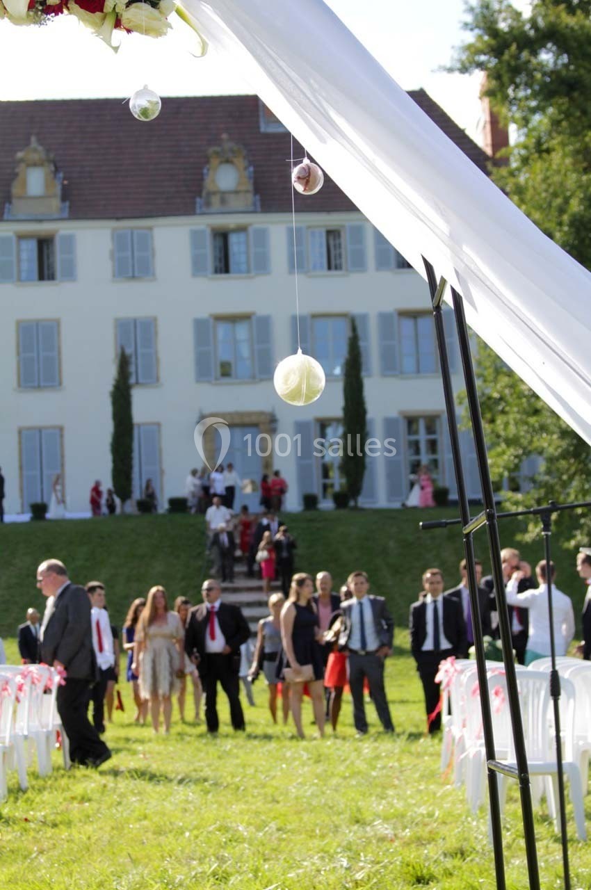 Location salle Roanne (Loire) - Château de Matel #40 Cérémonie en plein air avec invités rassemblés devant un bâtiment historique, décorée de voilages et ornements suspendus.