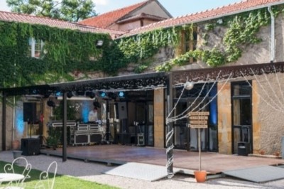Miniature Location salle Roanne (Loire) - Château de Matel #43 Allée gravillonnée bordée de lanternes blanches menant à un jardin arboré, vue depuis un portail en fer forgé.