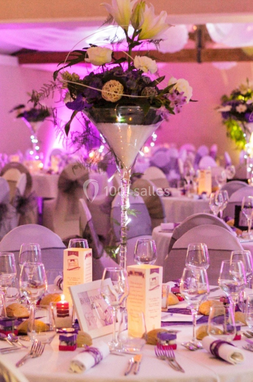 Location salle Roanne (Loire) - Château de Matel #12 Salle de réception décorée avec des tables élégantes, des fleurs en centre de table et une ambiance lumineuse tamisée.