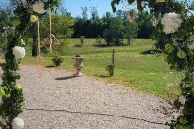 Miniature Location salle Roanne (Loire) - Château de Matel #37 Allée gravillonnée bordée de lanternes blanches menant à un jardin arboré, vue depuis un portail en fer forgé.