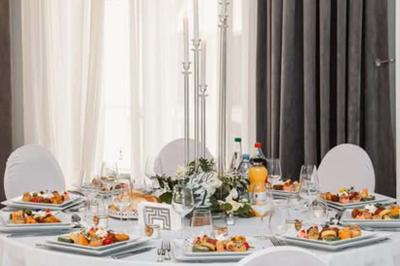 Présentation de desserts variés, notamment des cupcakes et gâteaux, disposés sur des étagères recouvertes de tissu vert.