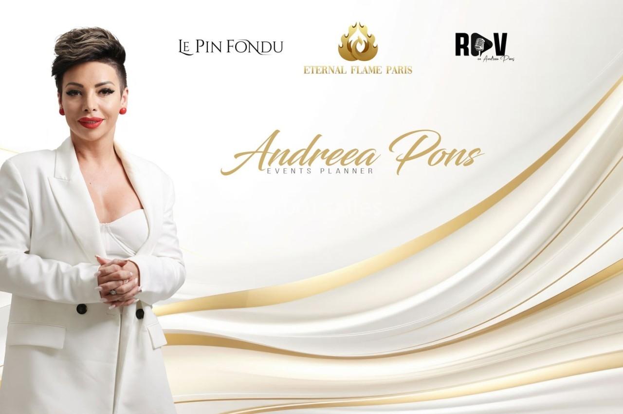 Femme en tailleur blanc posant devant un fond clair avec des logos et des motifs dorés.